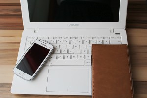 Photo of a smartphone and a tablet sitting on a laptop