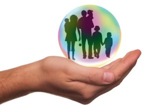 photograph depicting a hand holding a graphic of a family