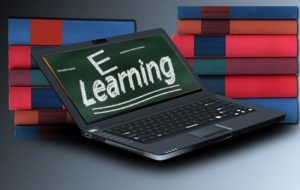 Graphic with a laptop floating in front of books with the words "E Learning" on the screen.